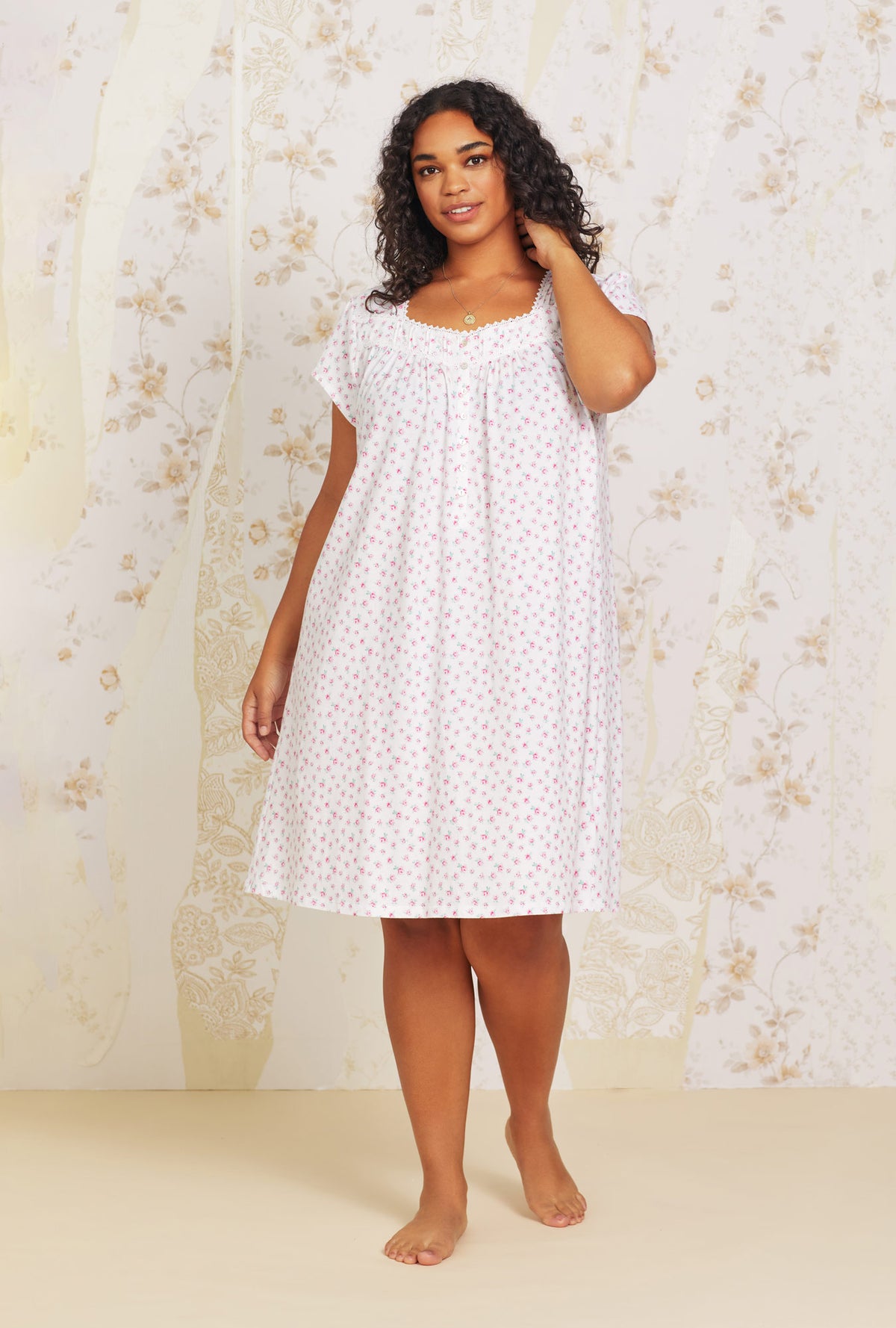 A lady wearing pink cap sleeve short cotton knit nightgown with joyful rose print.