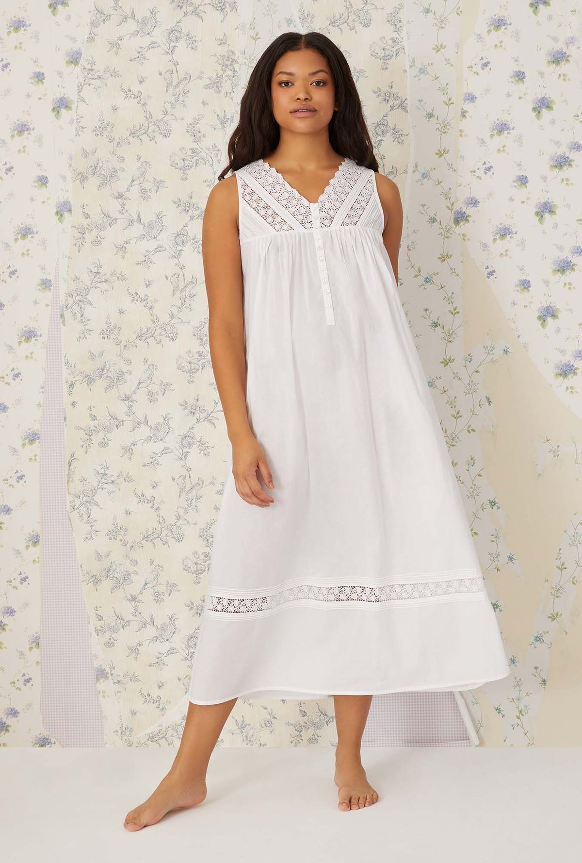 A lady wearing white sleeveless portofino ballet nightgown.