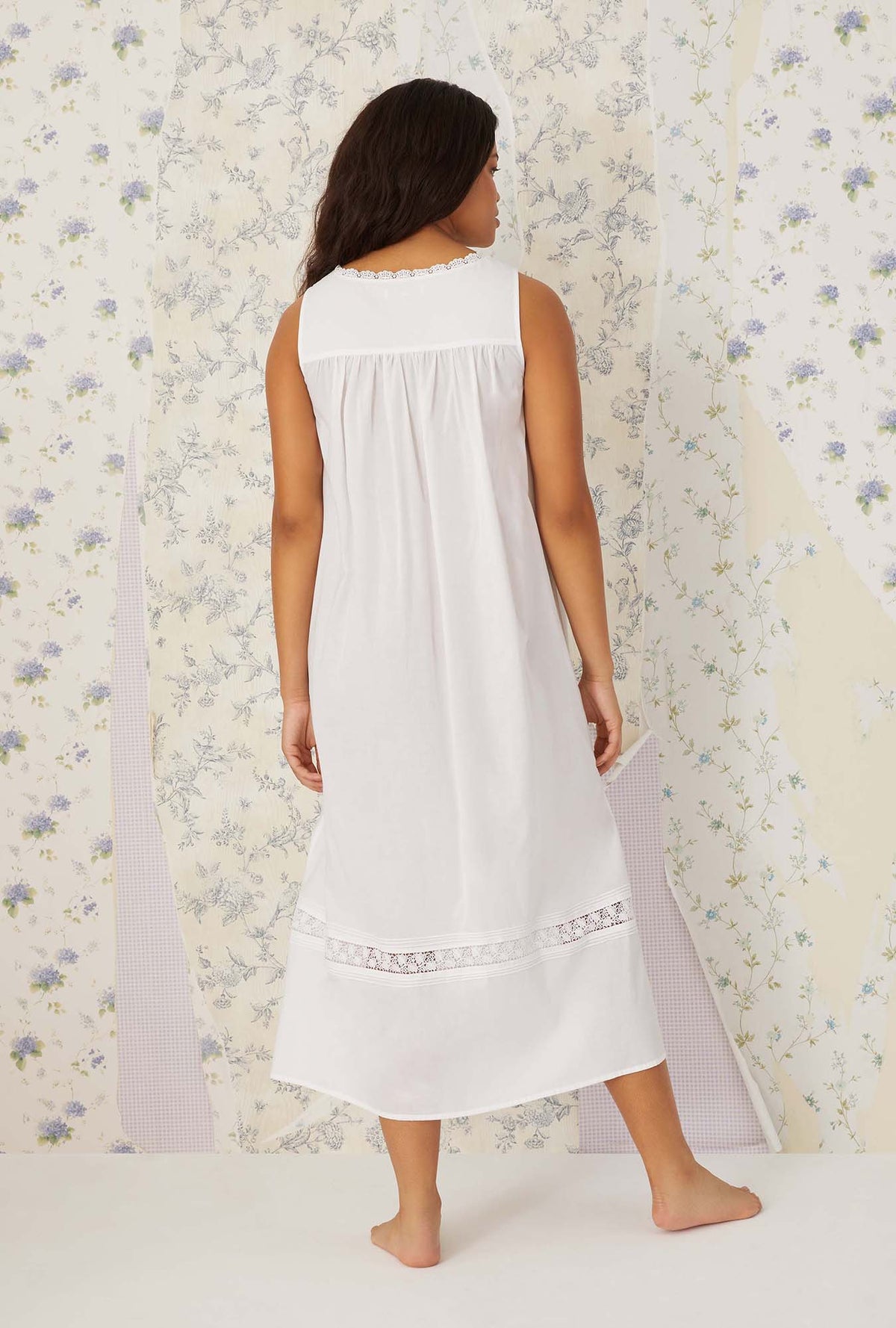 A lady wearing white sleeveless portofino ballet nightgown.