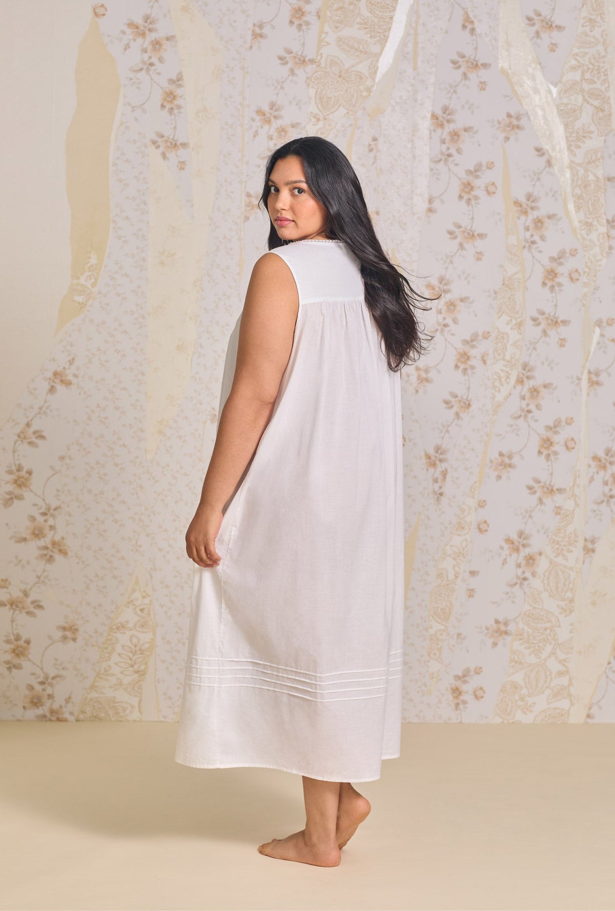 A lady wearing white sleeveless poetic ballet plus size gown.