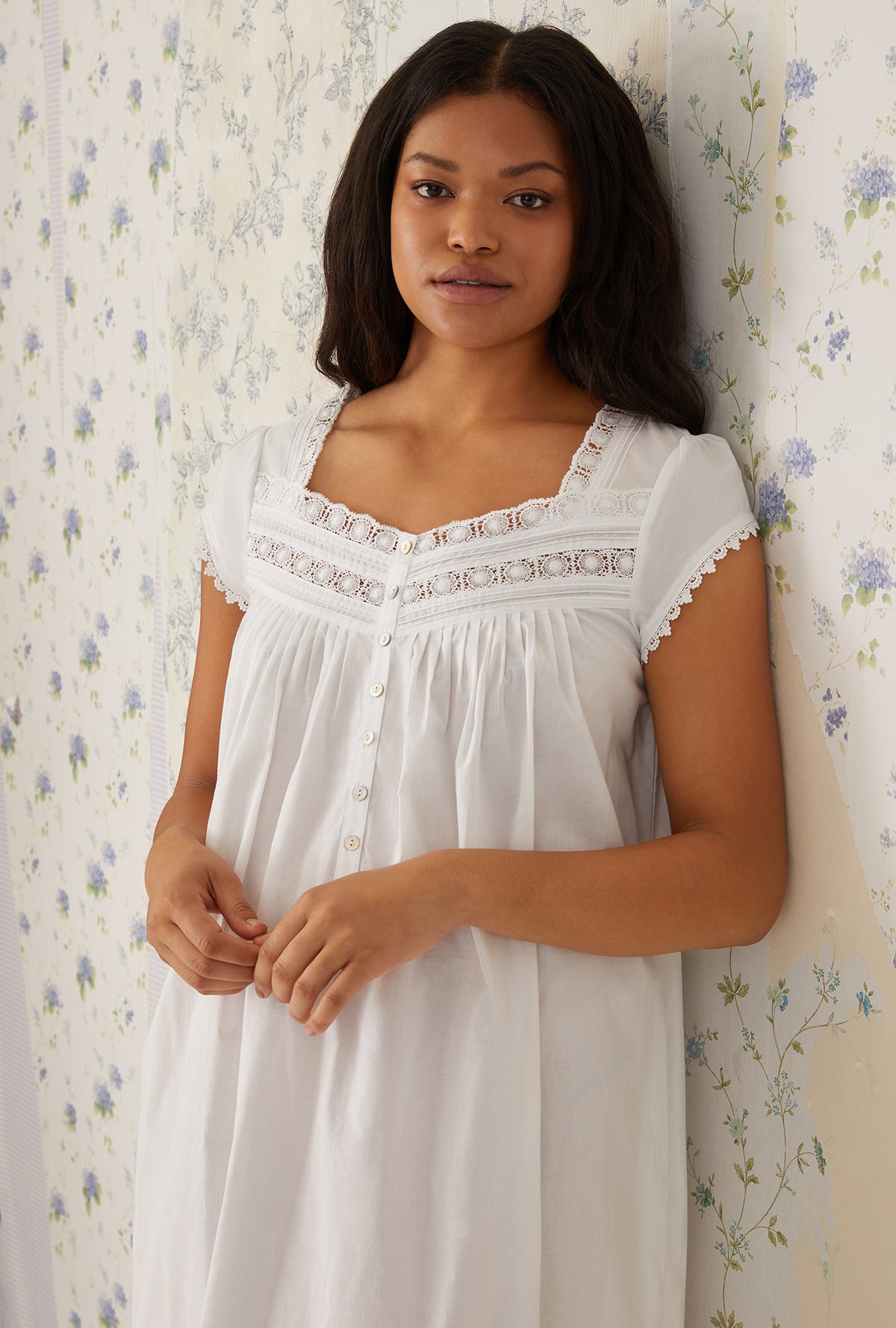 A lady wearing a white cap sleeve gown.