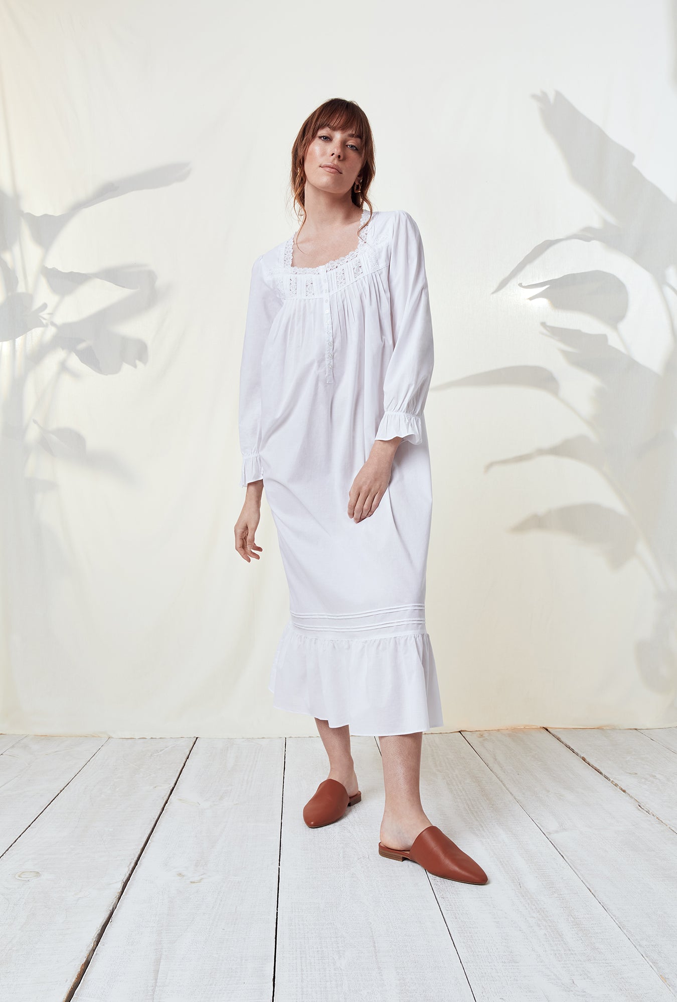 A lady wearing a white long sleeve nightgown.