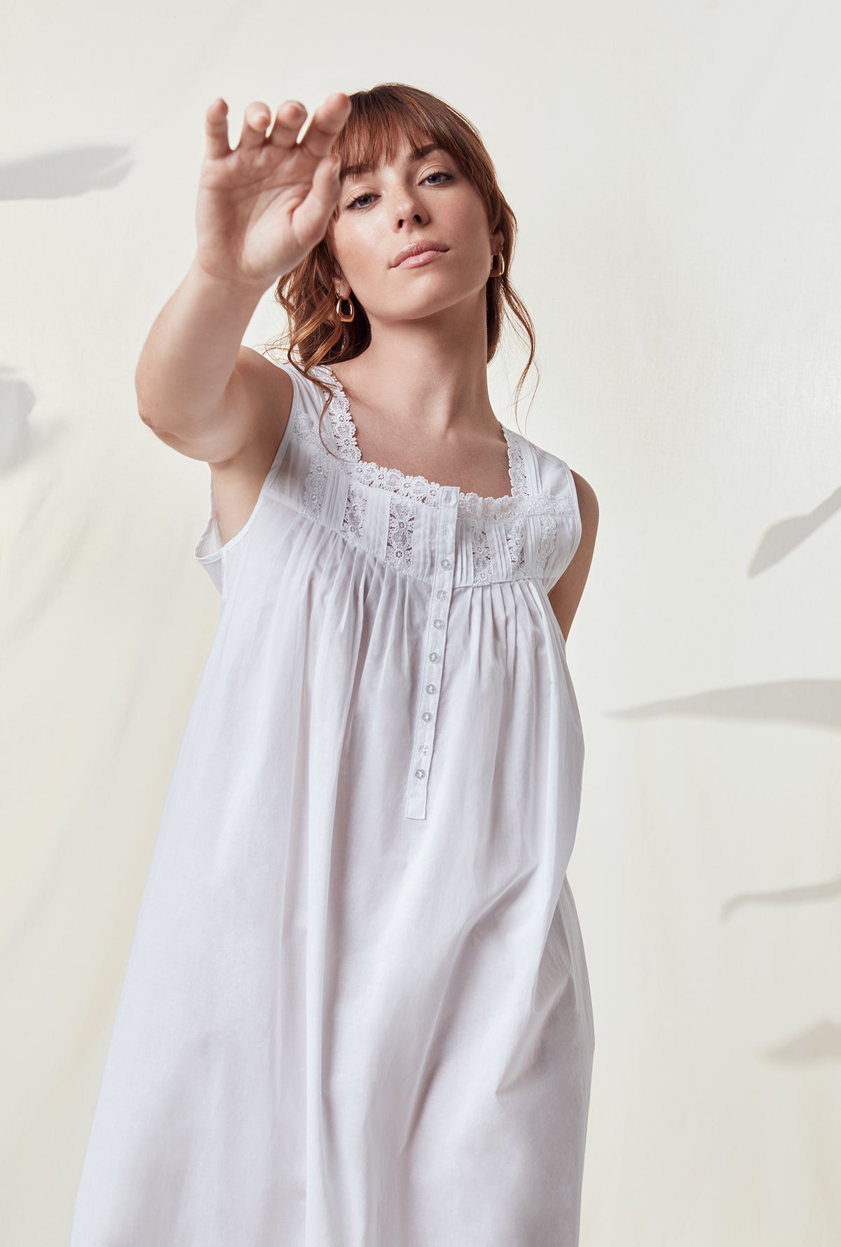 A lady wearing a white sleeveless nightgown.