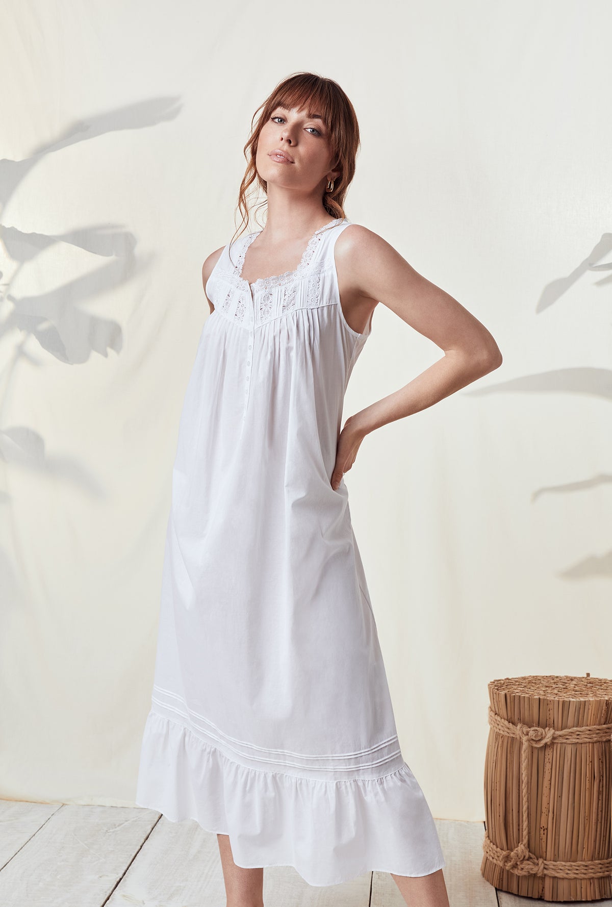 A lady wearing a white sleeveless nightgown.