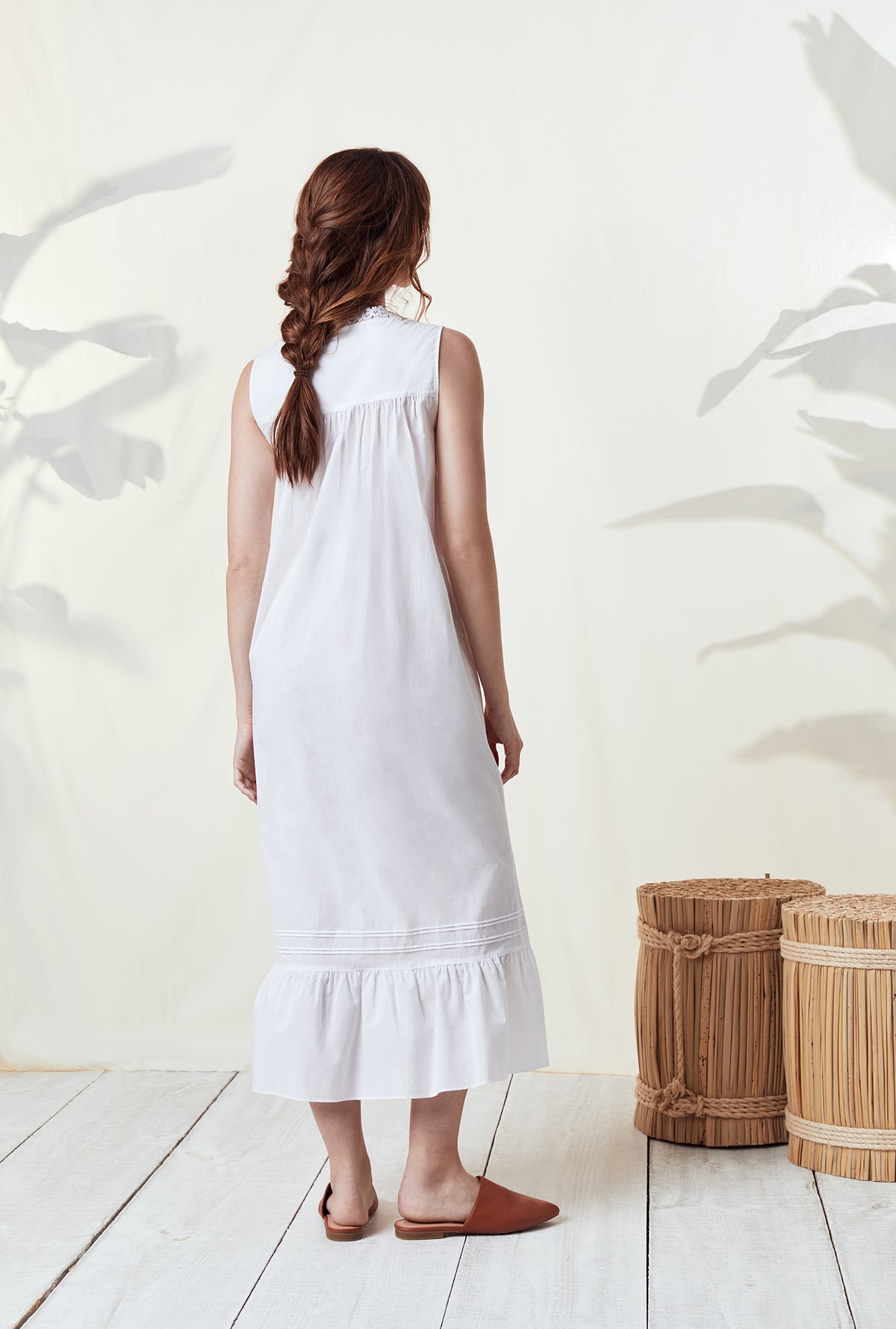 A lady wearing a white sleeveless nightgown.