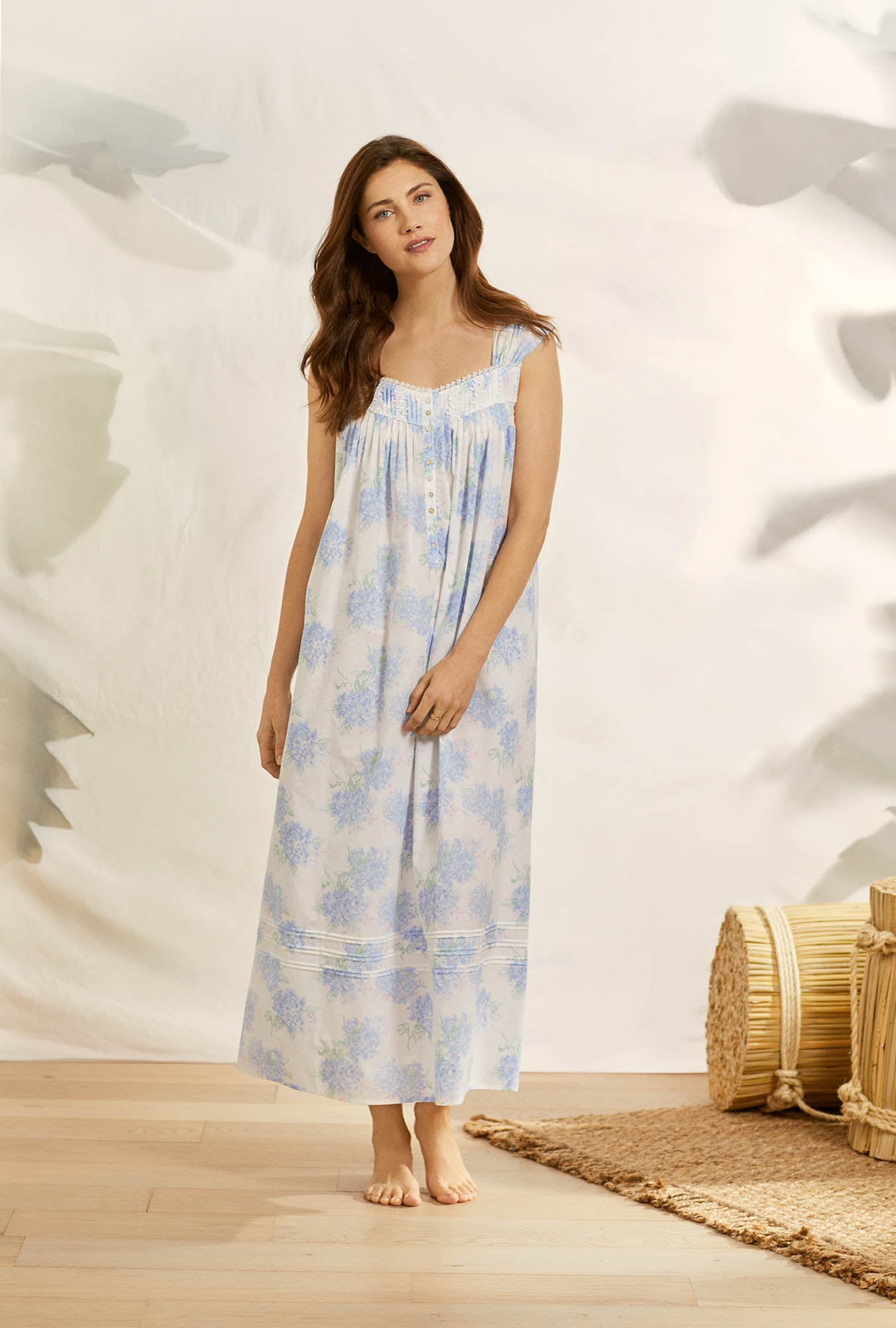 A lady wearing white sleeveless taylor  nightgown with hydrangea blossom print.