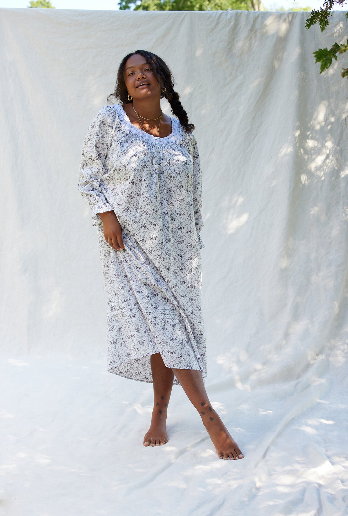 A lady wearing a grey ribbon floral long sleeve cotton nightgown.