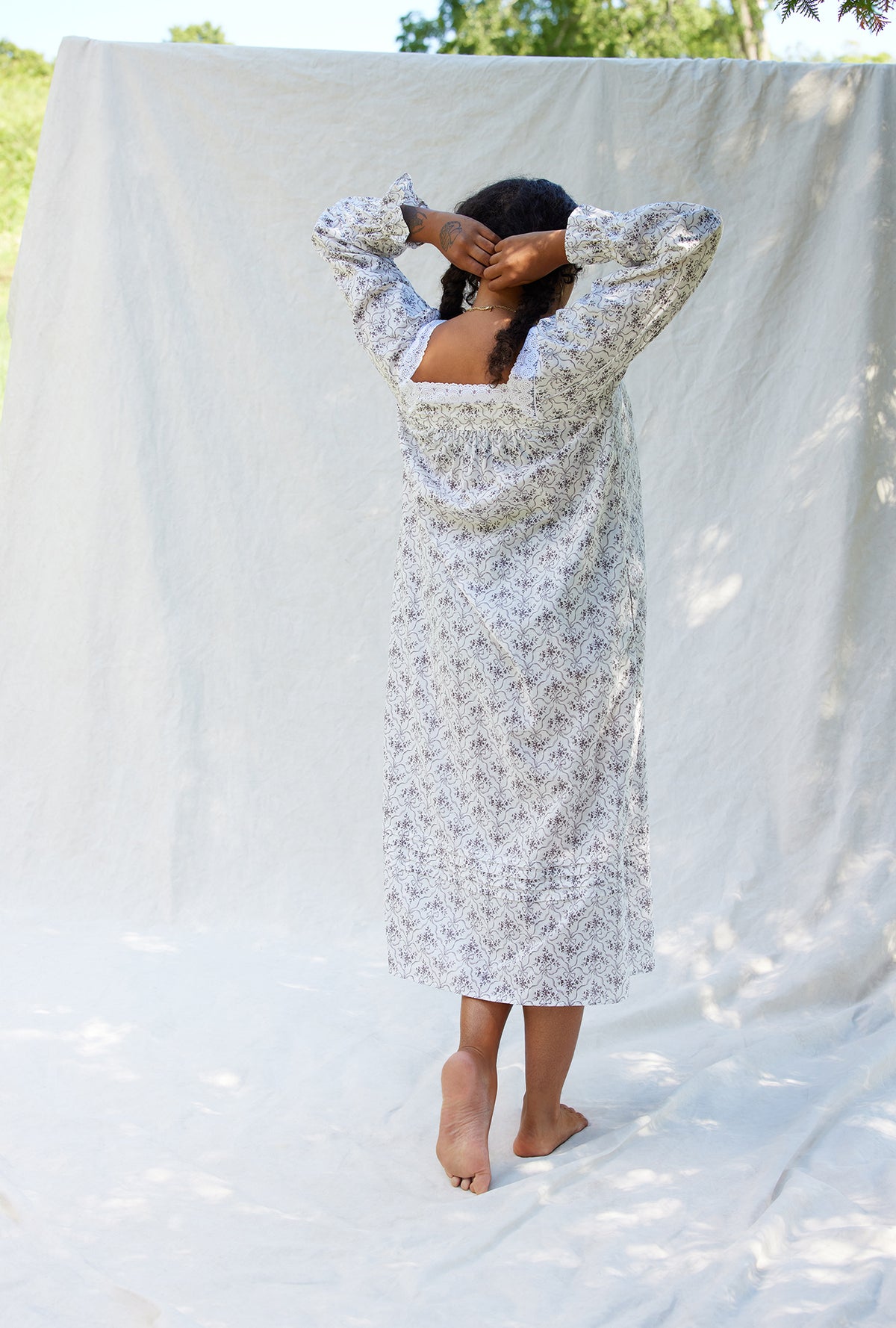 A lady wearing a grey ribbon floral long sleeve cotton nightgown.