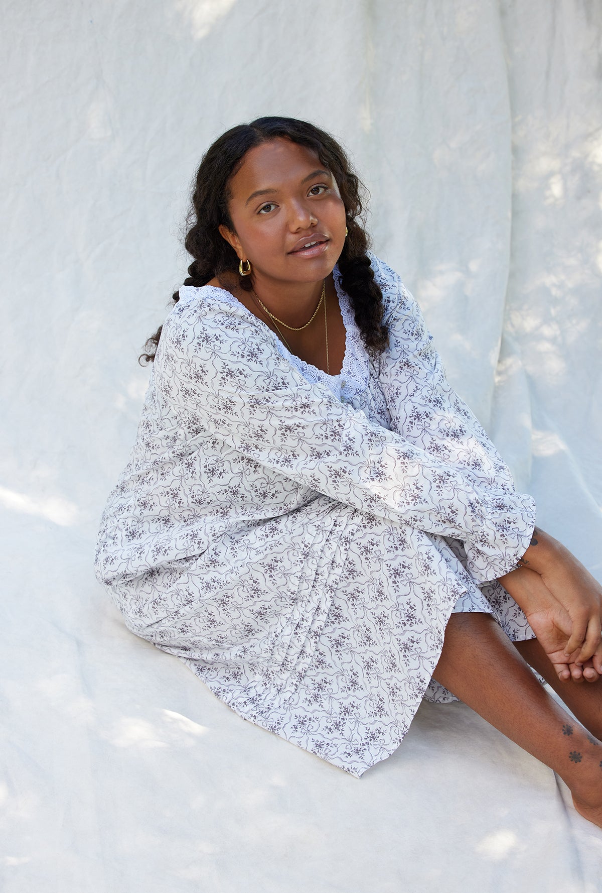 A lady wearing a grey ribbon floral long sleeve cotton nightgown.