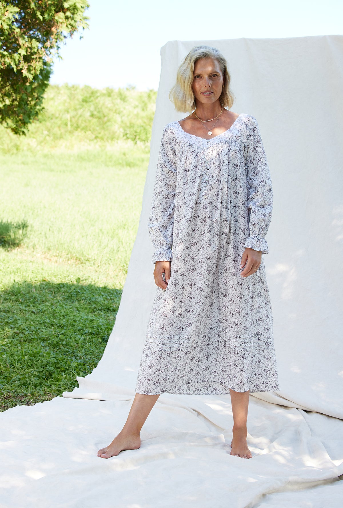 A lady wearing a grey ribbon floral long sleeve cotton nightgown.
