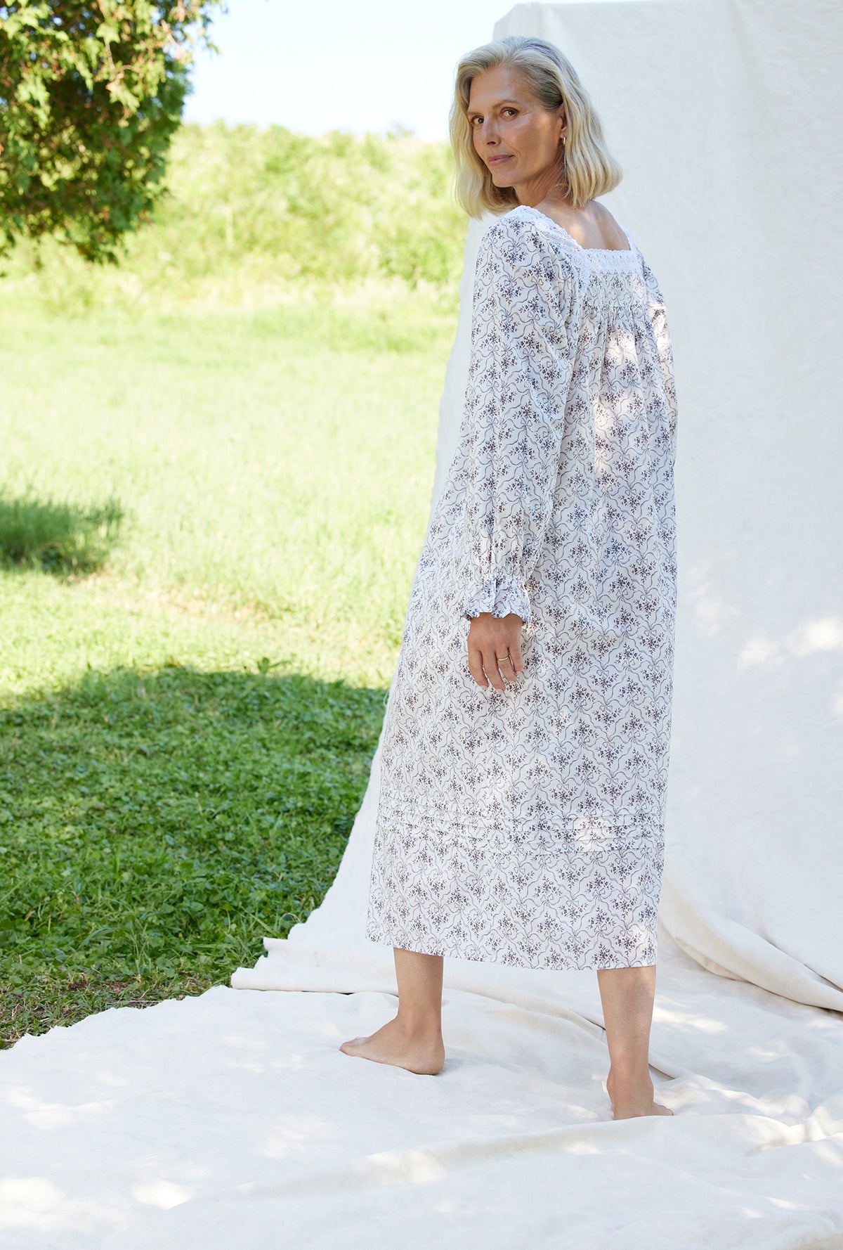 A lady wearing a grey ribbon floral long sleeve cotton nightgown.