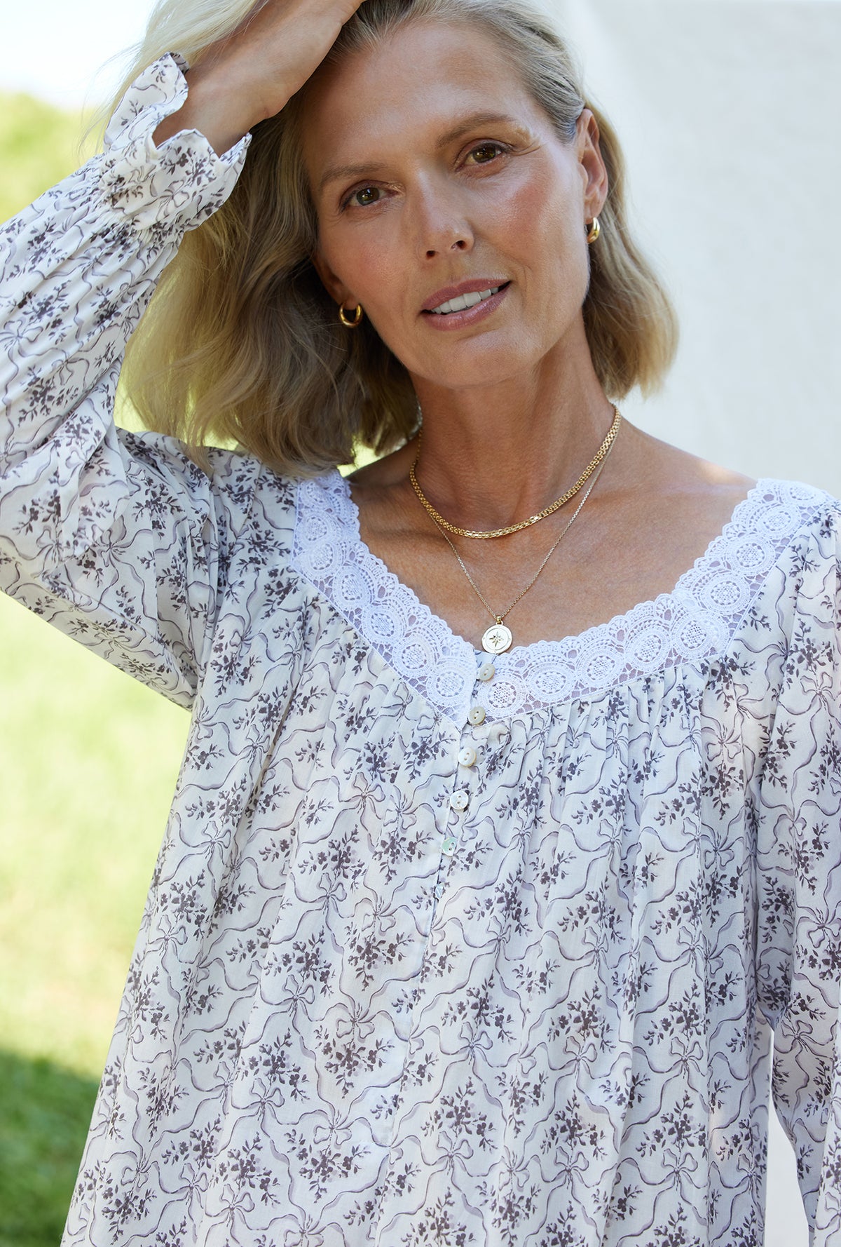 A lady wearing a grey ribbon floral long sleeve cotton nightgown.