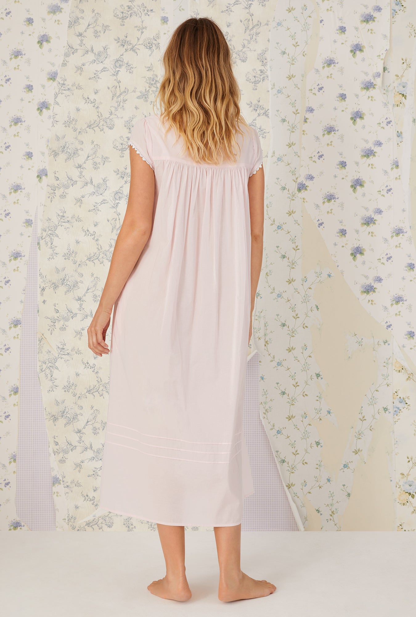 A lady wearing a white cap sleeve gown.