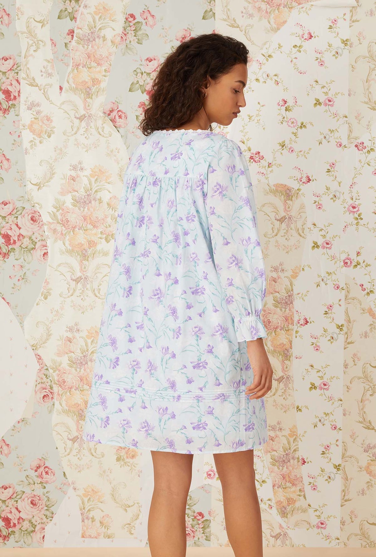 A lady wearing lavender carnations short robe.