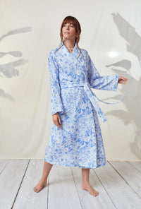 A lady wearing a blooming roses long sleeve wrap robe.