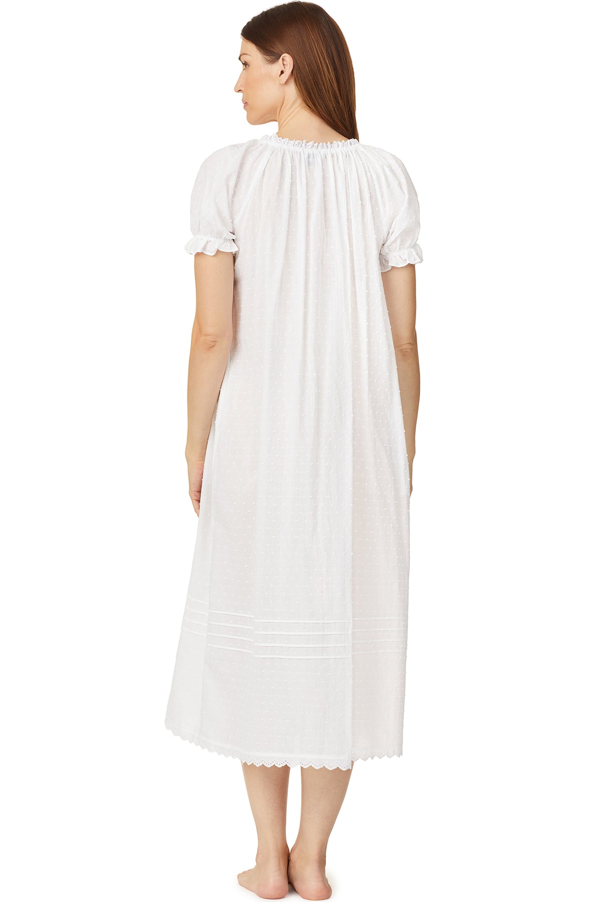 A lady wearing a white cap sleeve long nightdress with white dot pattern.
