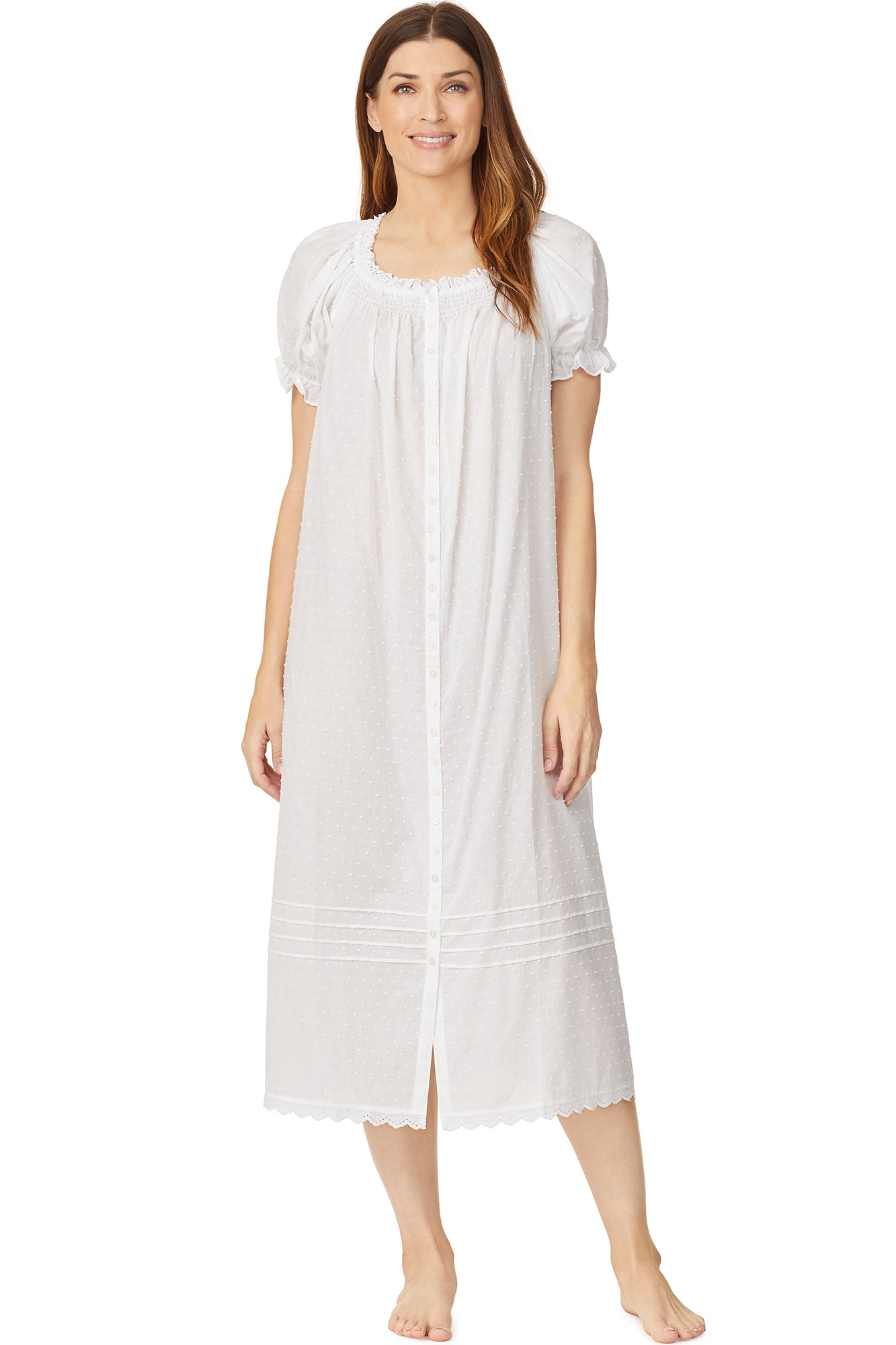 A lady wearing a white cap sleeve long nightdress with white dot pattern.