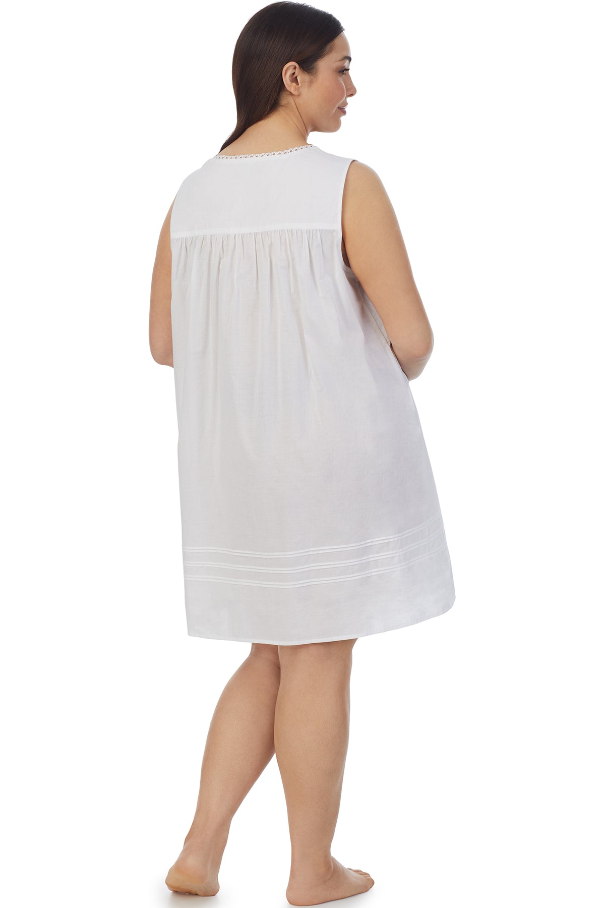 A lady wearing a white sleeveless short chemise.