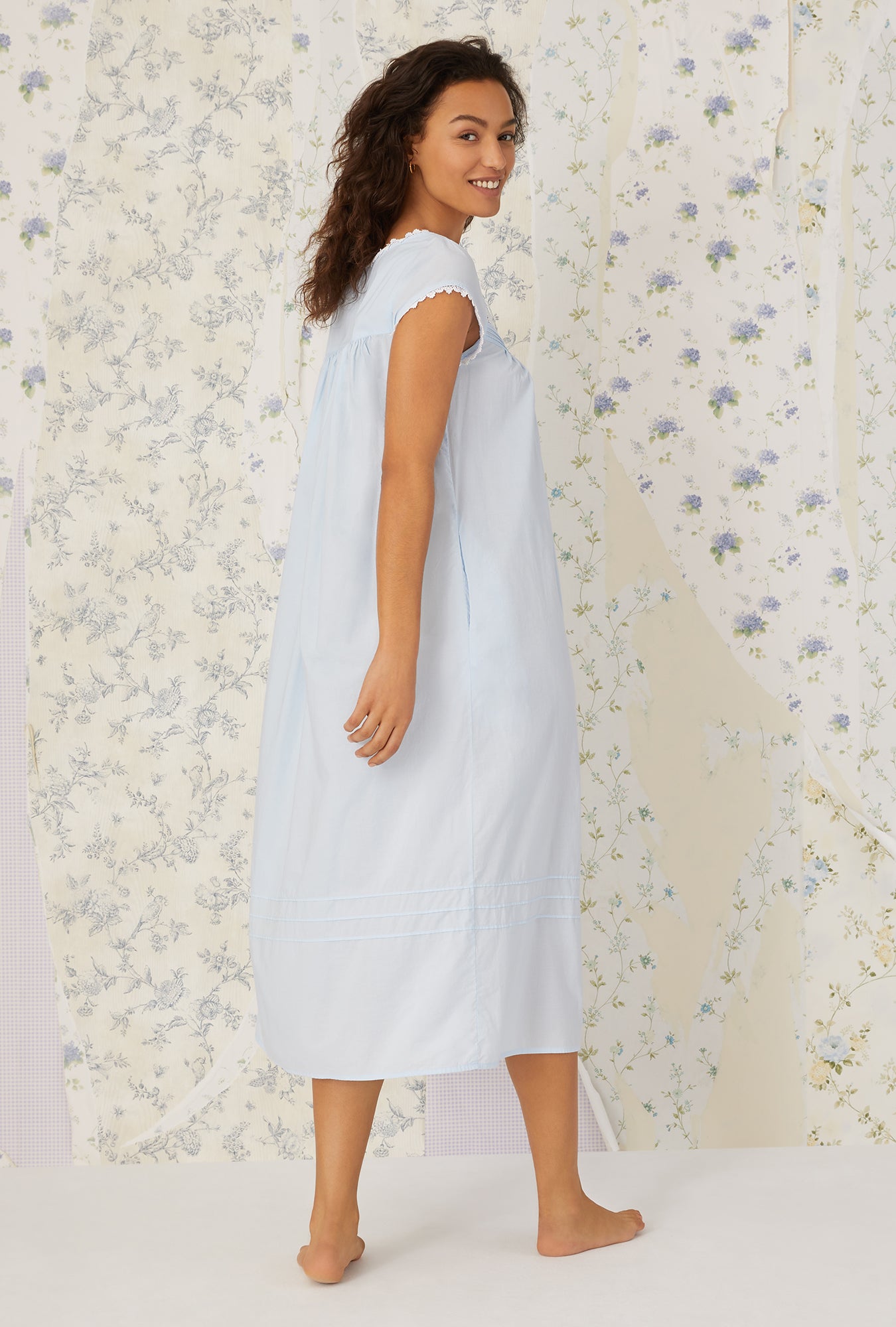 A lady wearing a white cap sleeve gown.