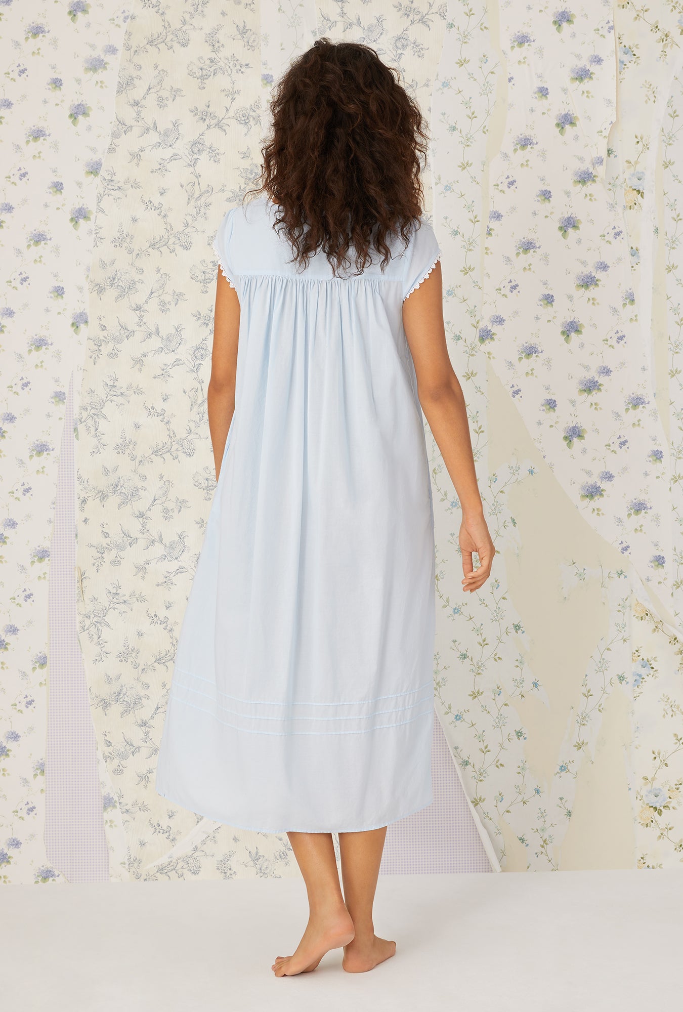 A lady wearing a white cap sleeve gown.