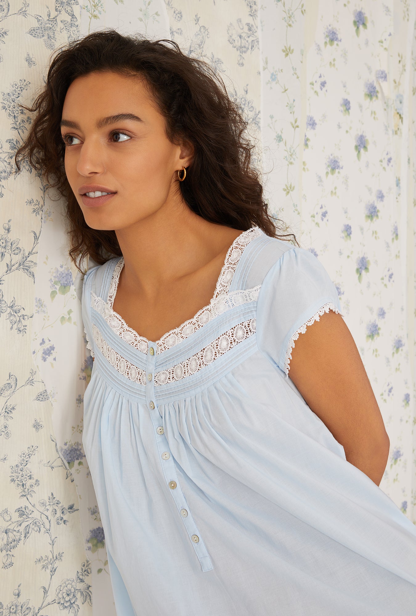 A lady wearing a white cap sleeve gown.