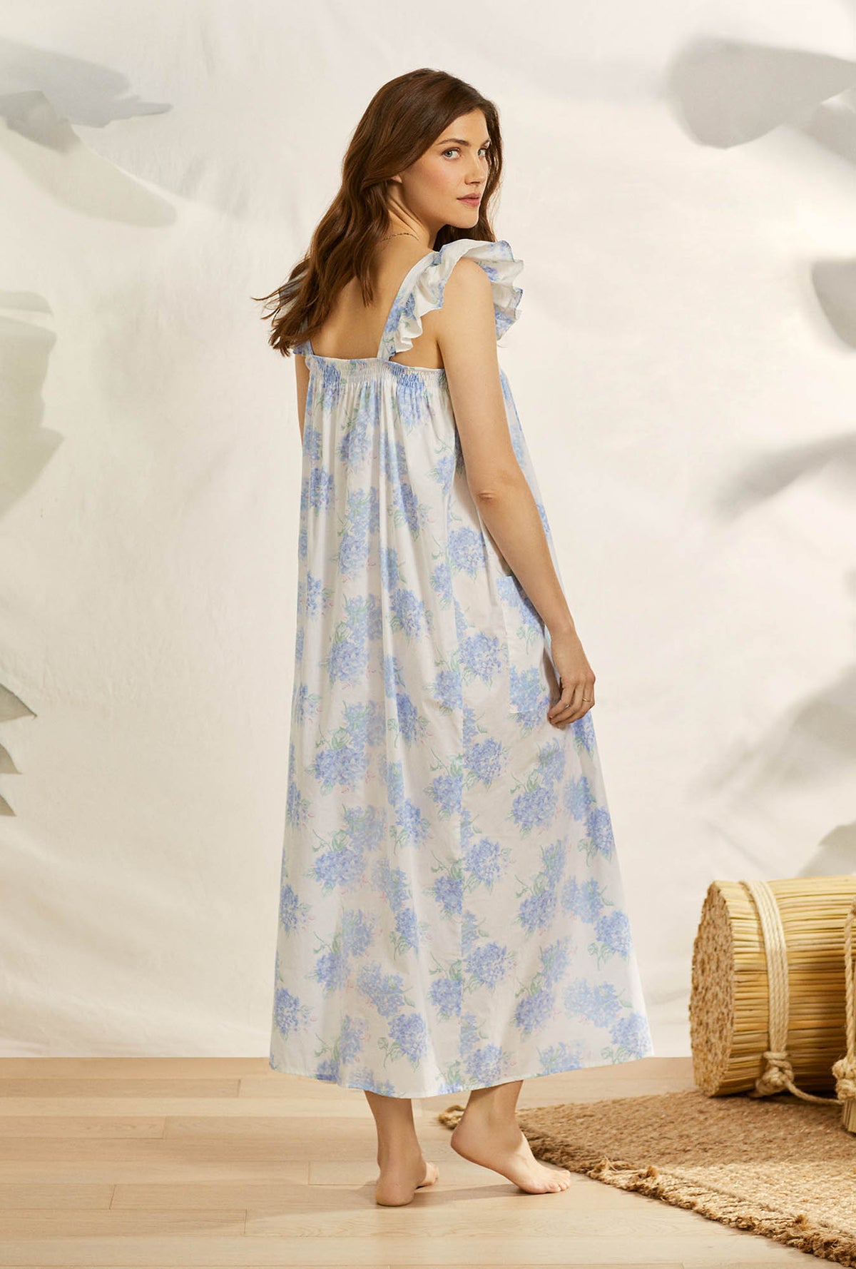 A lady wearing white butterfly sleeve angeline nightgown with hydrangea blossom print.