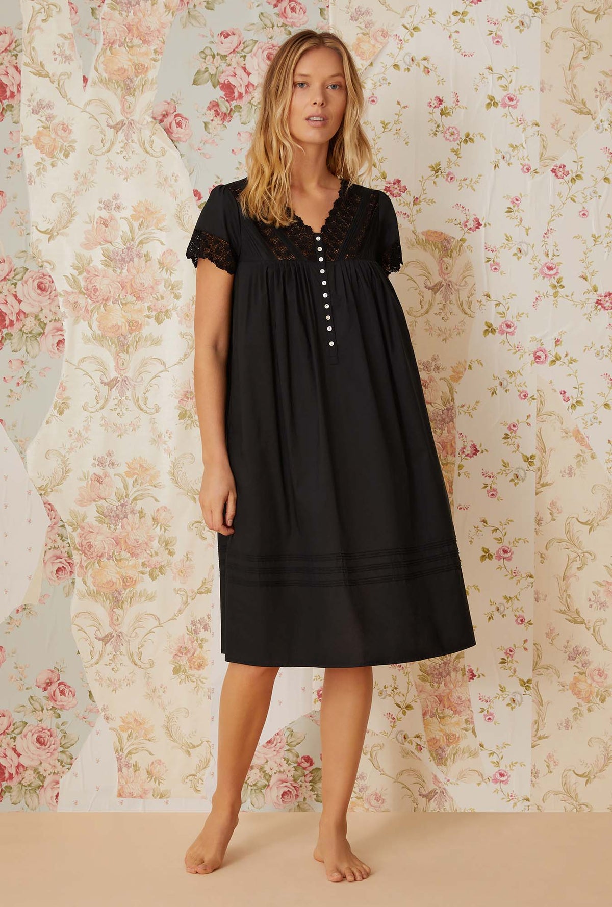 A lady wearing black short sleeve portofino waltz nightgown.