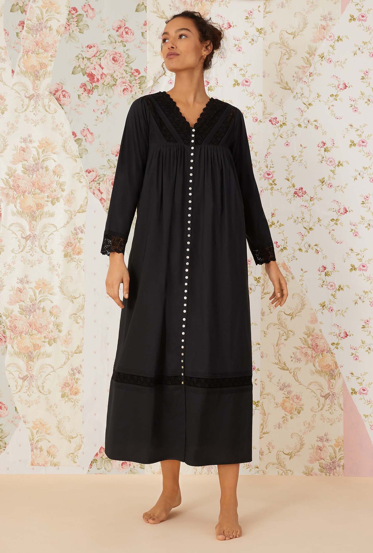 A lady wearing black long sleeve portofino ballet button front robe.