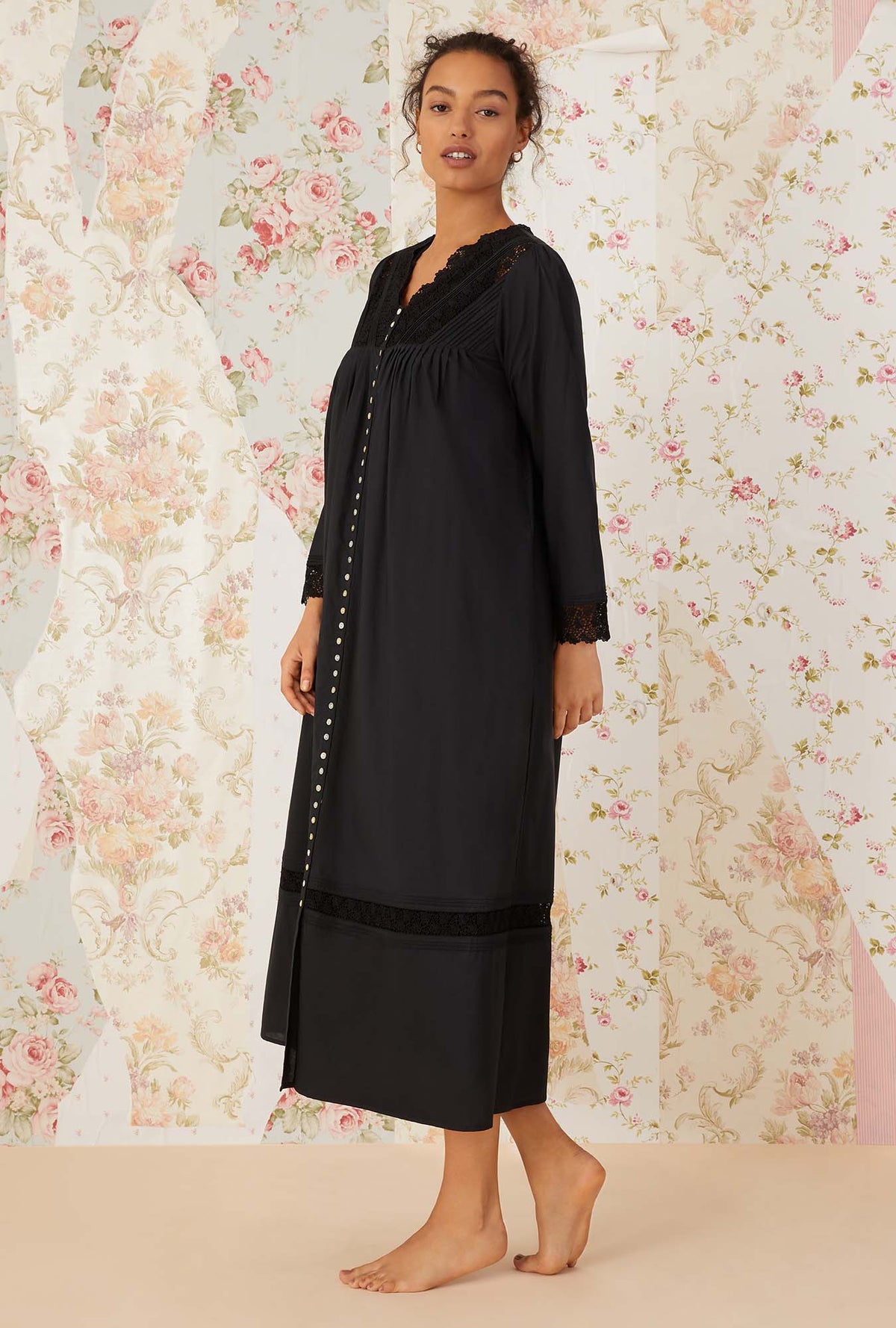 A lady wearing black long sleeve portofino ballet button front robe.