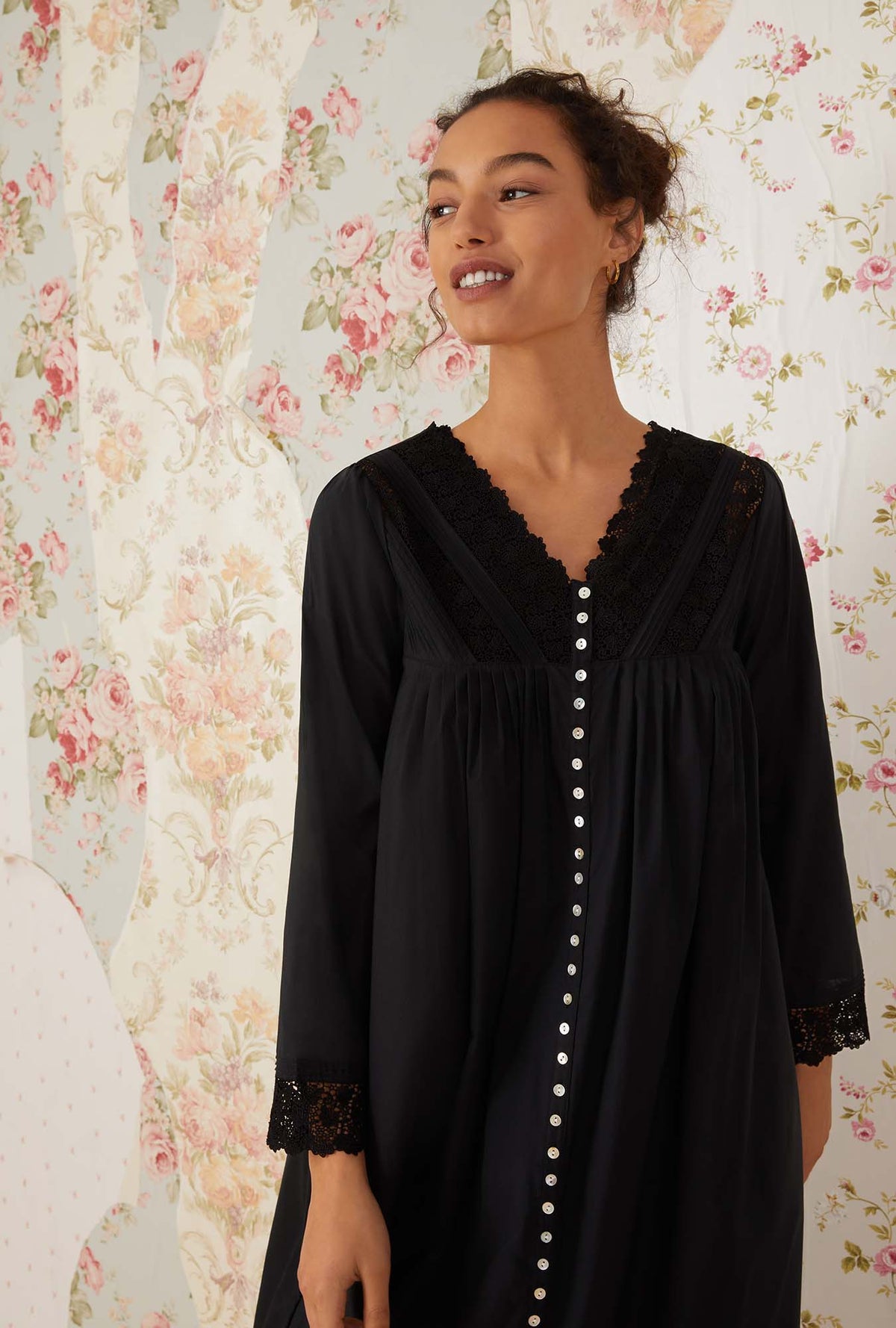 A lady wearing black long sleeve portofino ballet button front robe.