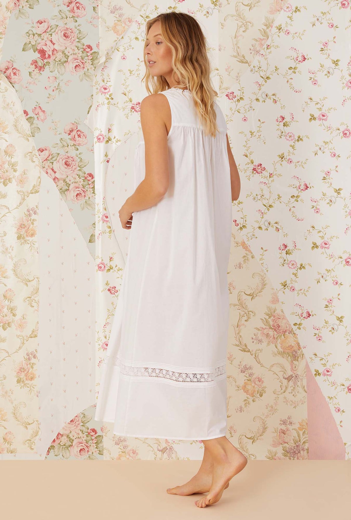 A lady wearing white sleeveless portofino ballet nightgown.