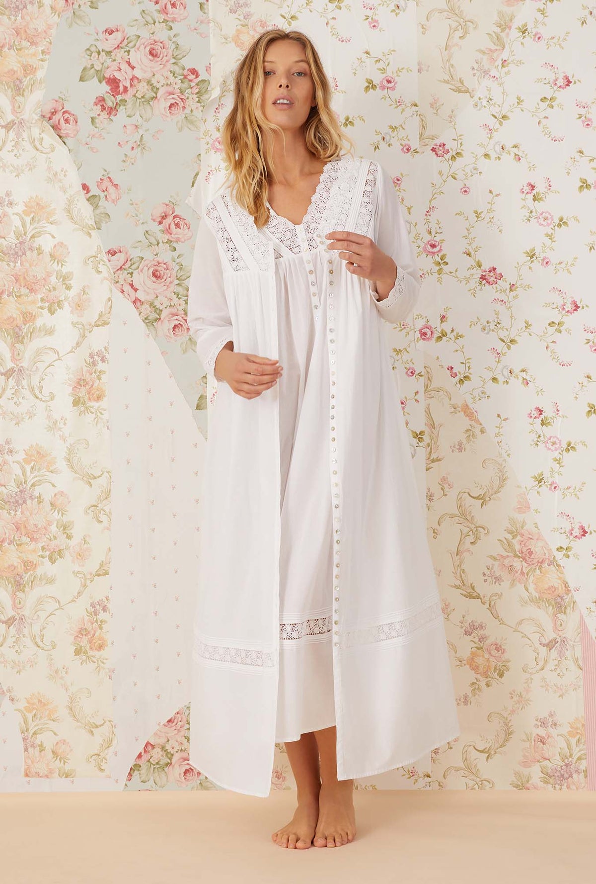 A lady wearing white long sleeve portofino ballet button front robe.