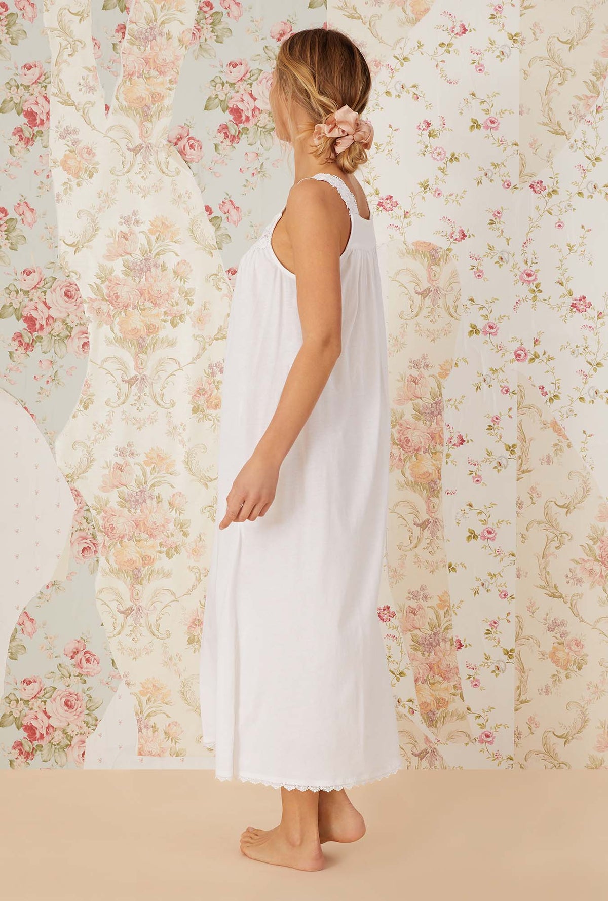 A lady wearing white sleeveless villa blanca knit ballet nightgown.