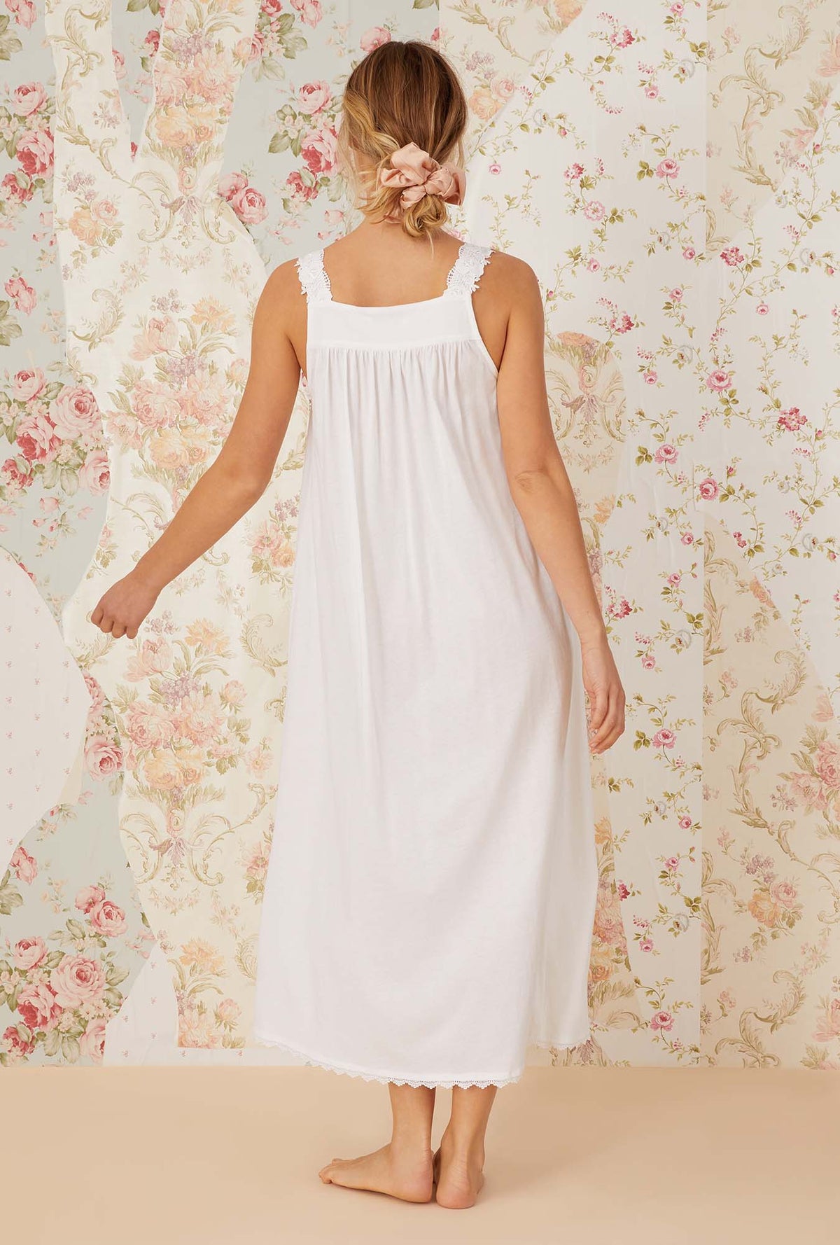 A lady wearing white sleeveless villa blanca knit ballet nightgown.