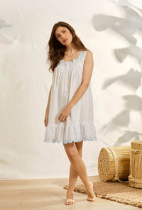 A lady wearing white sleeveless eileen scallop floral embroidery chemise.