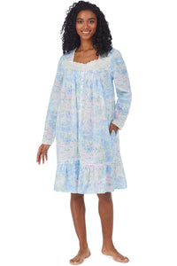 A lady wearing a white long sleeve short robe with blue floral print.