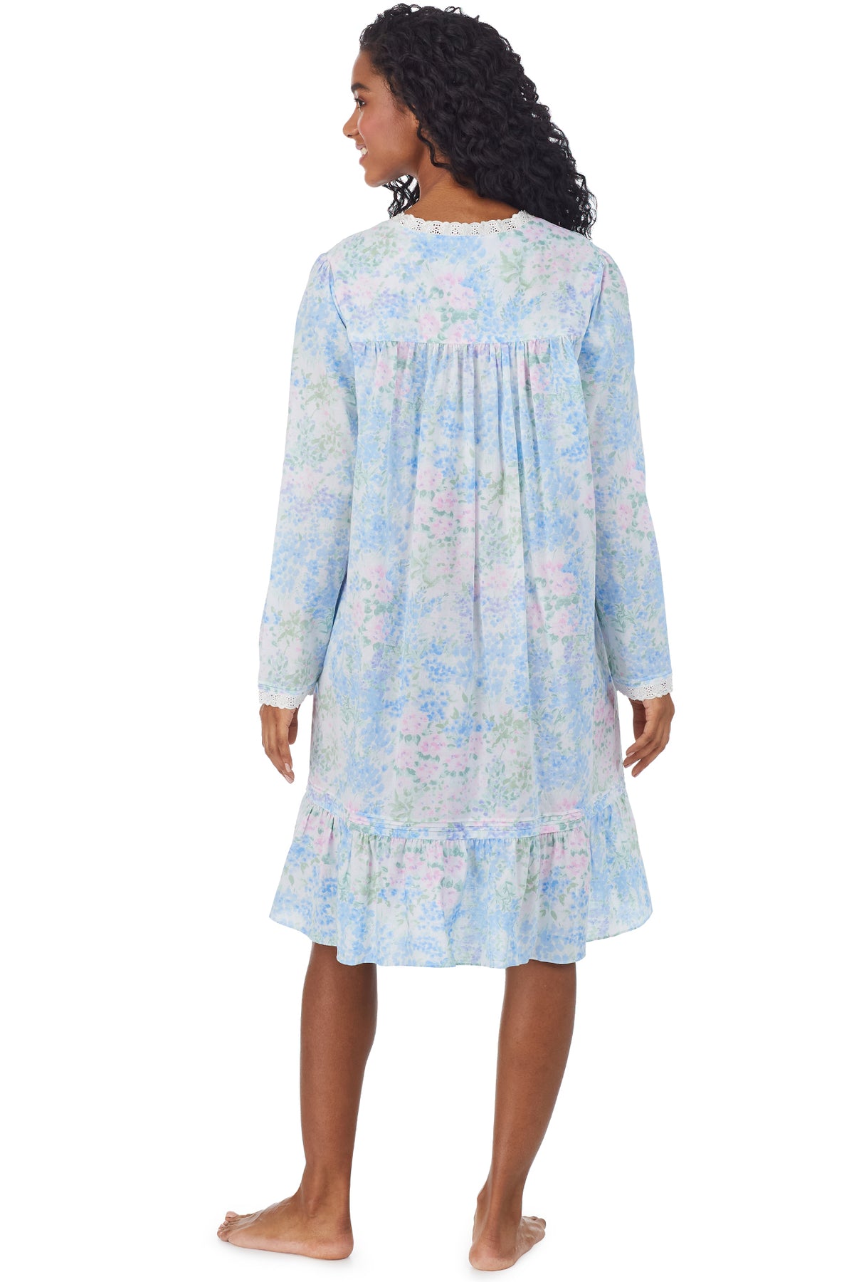 A lady wearing a white long sleeve short robe with blue floral print.