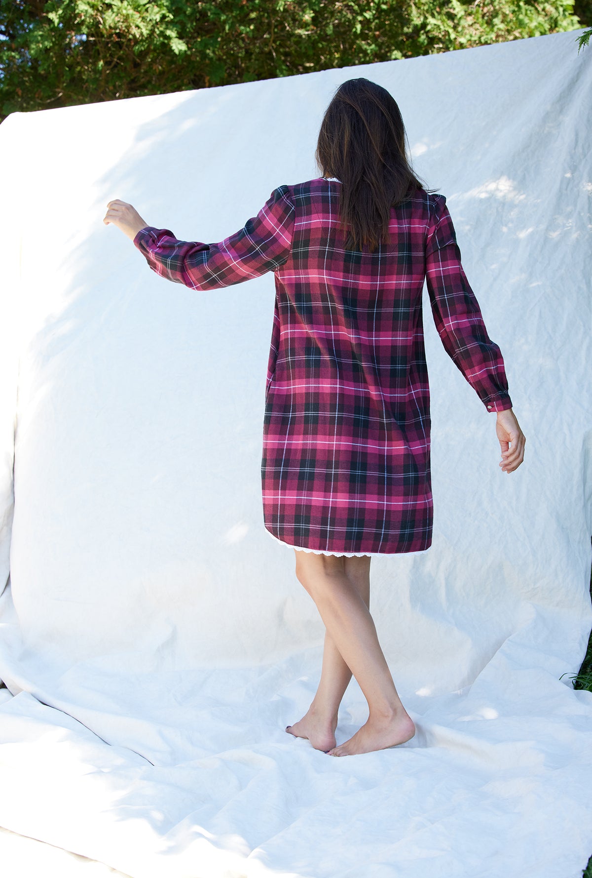 A lady wearing a holly berry plaid rayon long sleeve lightweight flannel nightshirt.