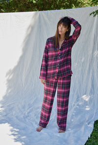 A lady wearing a holly berry plaid long sleeve rayon lightweight  flannel notch collar pajama.
