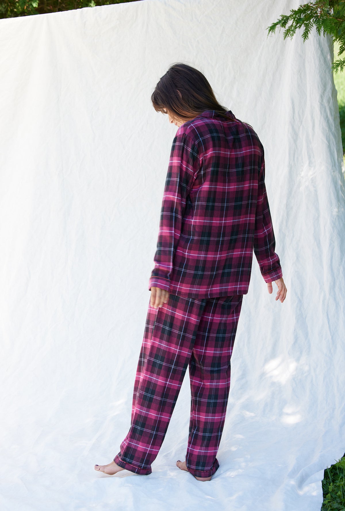 A lady wearing a holly berry plaid long sleeve rayon lightweight  flannel notch collar pajama.