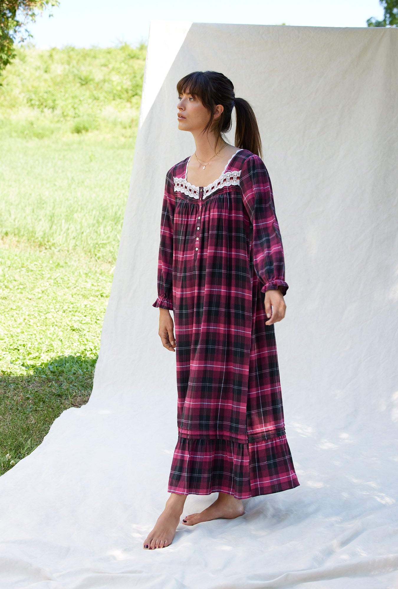 A lady wearing a holly berry plaid rayon lightweight flannel long nightgown.