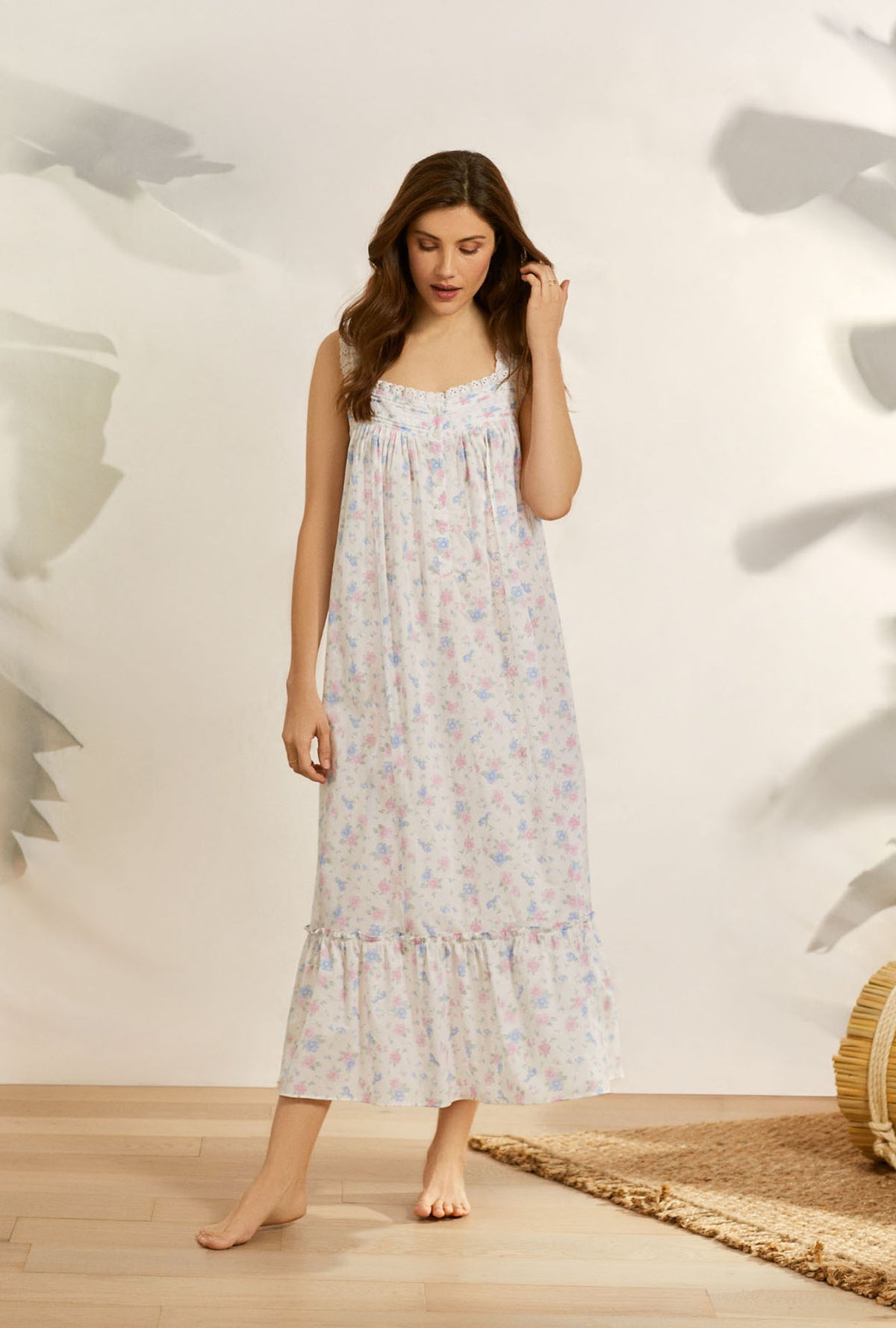 A lady wearing white sleeveless eileen nightgown with delicate floral print.