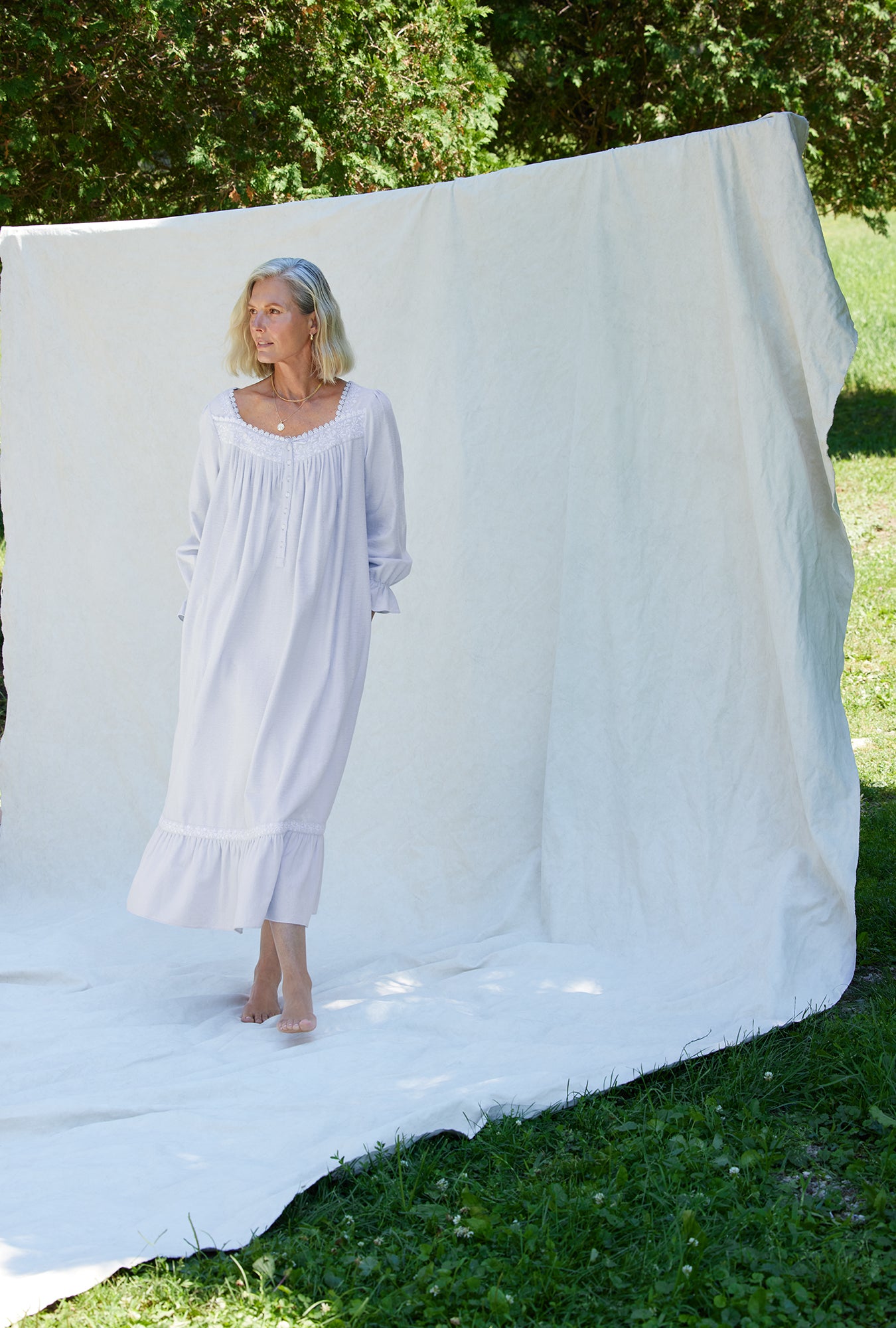A lady wearing a white long sleeve cotton flannel embroidery nightgown.