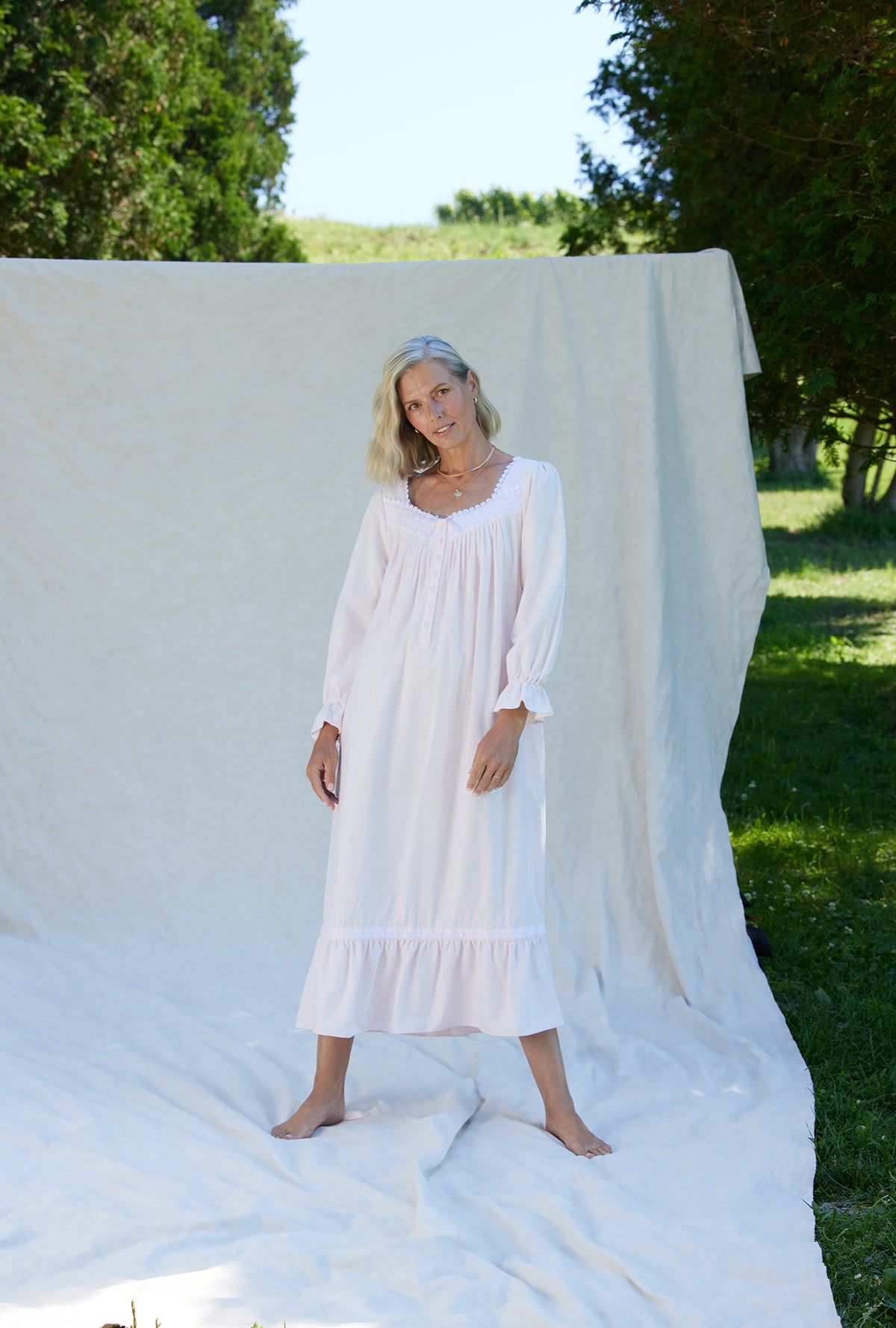 A lady wearing a white long sleeve cotton flannel embroidery nightgown.