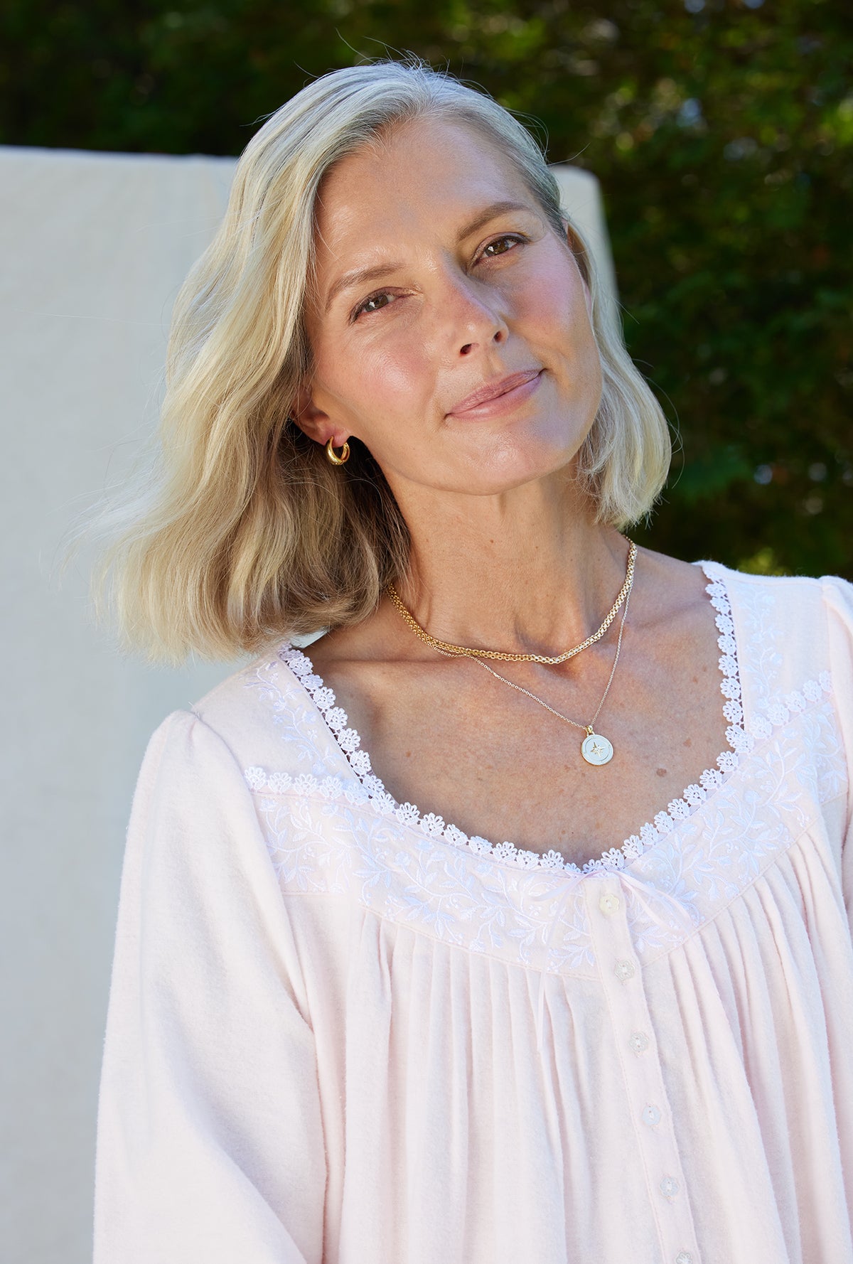 A lady wearing a white long sleeve cotton flannel embroidery nightgown.