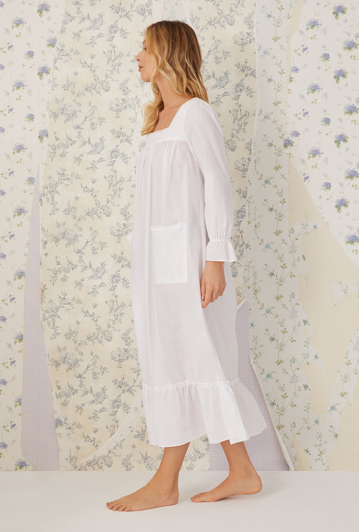 A lady wearing a white long sleeve &quot;rebecca&quot; Nightgown.