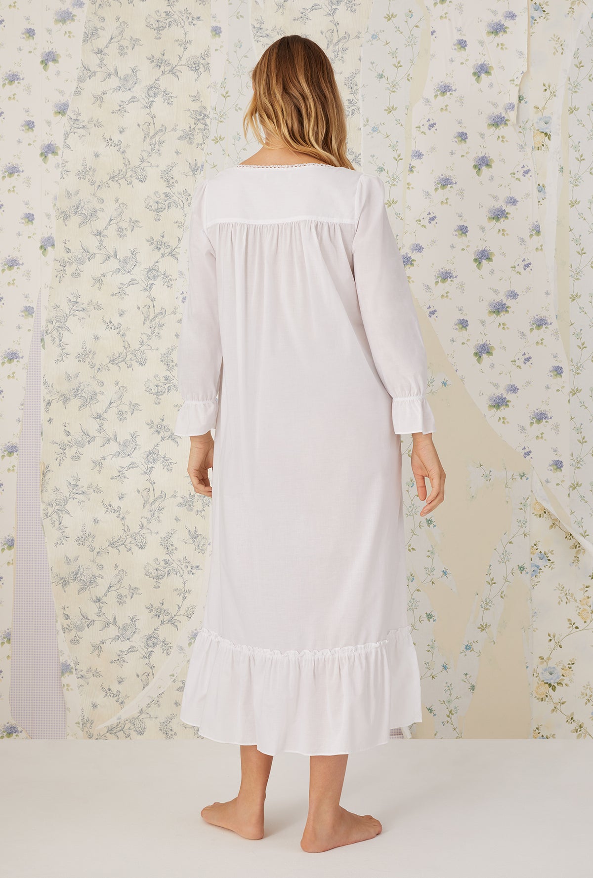 A lady wearing a white long sleeve &quot;rebecca&quot; Nightgown.