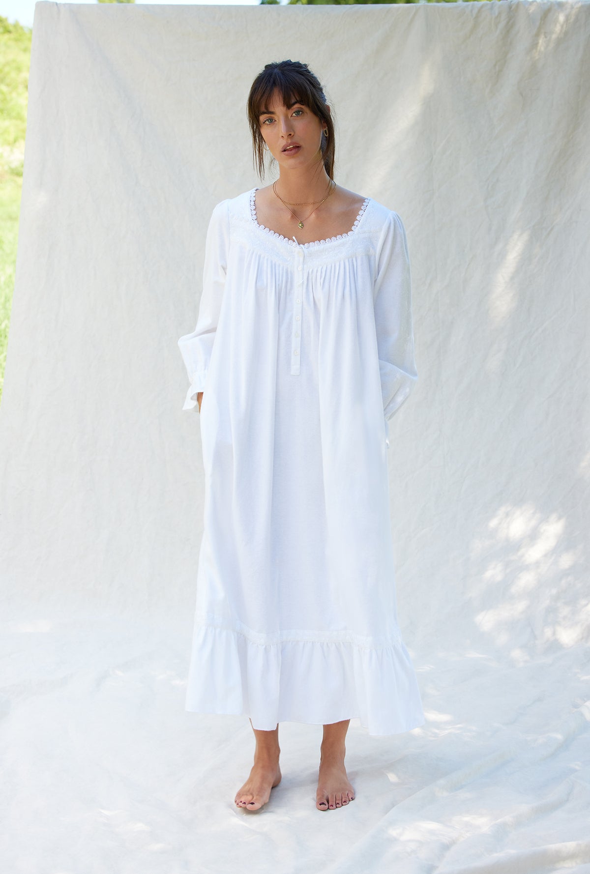A lady wearing a white long sleeve cotton flannel embroidery nightgown.