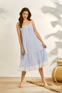 A lady wearing blue sleeveless angela nightgown with seaside dream stripe print.