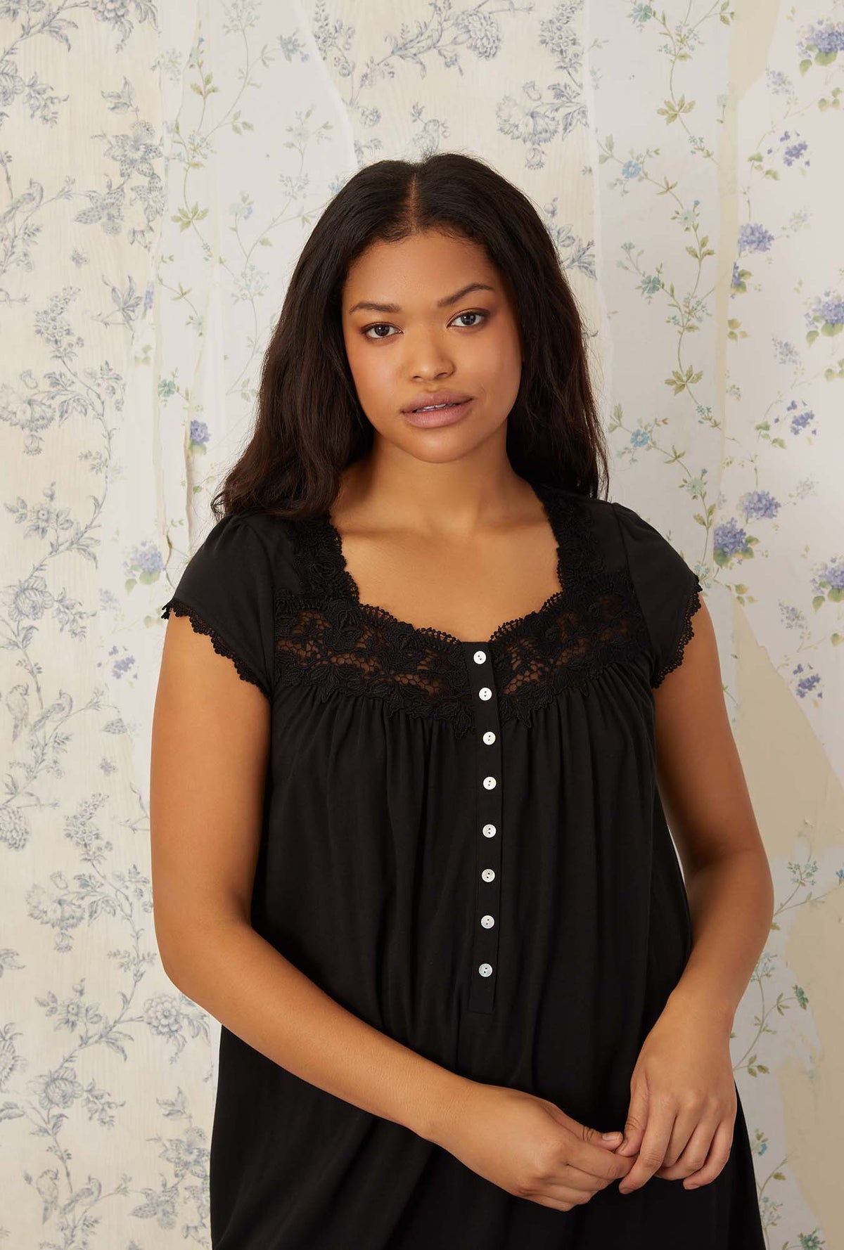 A lady wearing plus size black villa blanca waltz knit nightgown in a half close up shot